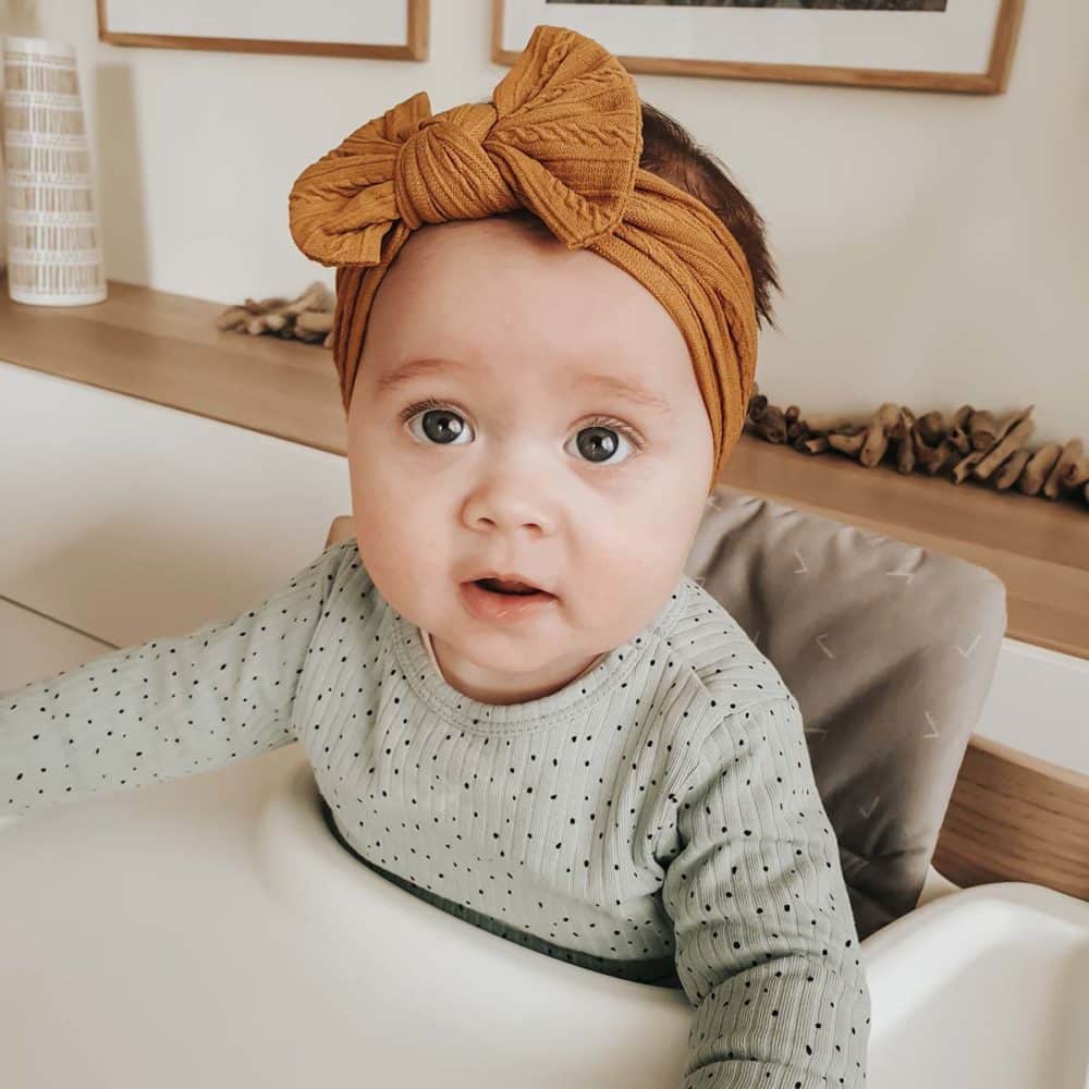 Baby with mustard colored headband